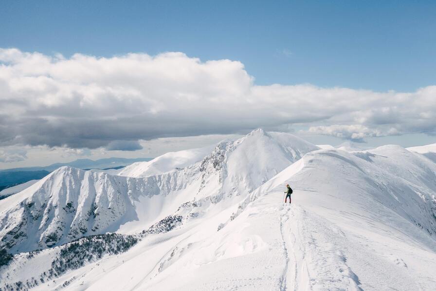 a person on top of the snowy peak in kashmir